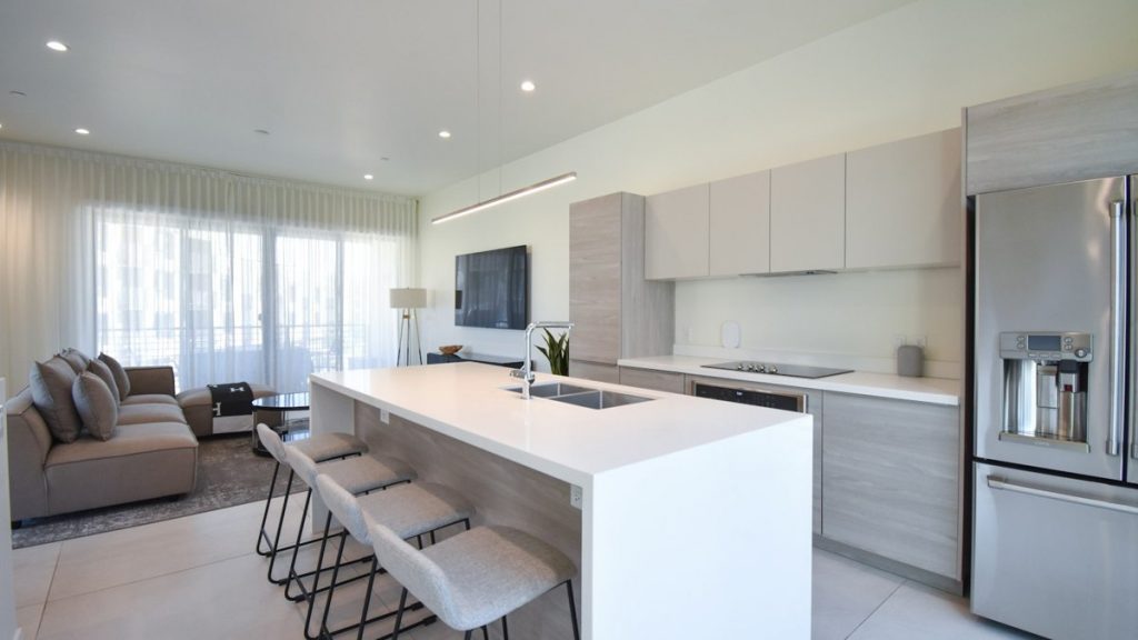Cocina moderna renovada con isla en un piso de Zaragoza